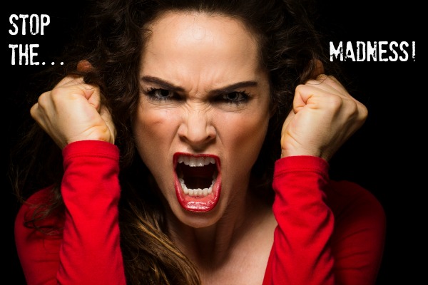 A very angry aggressive woman is clenching her fists in rage