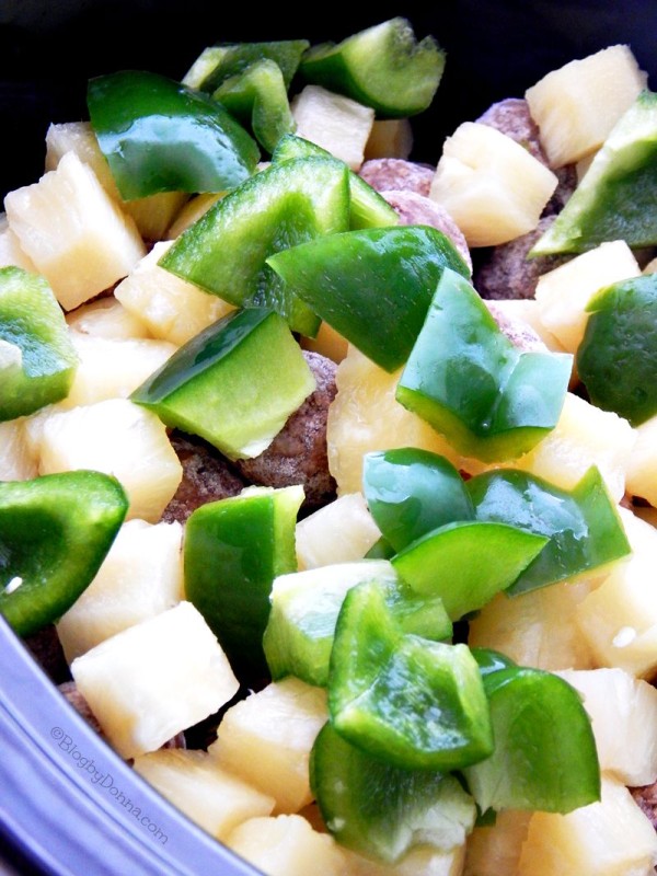 Pour frozen meatballs, pineapple, and chunks of green pepper into the crock pot.