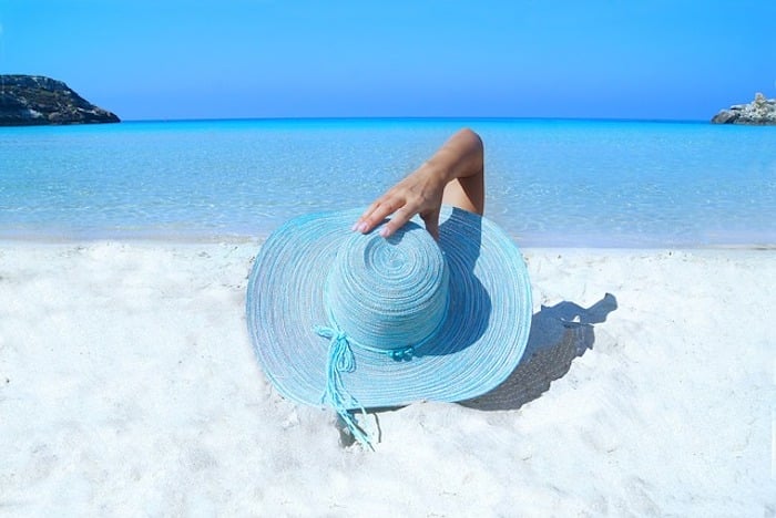 woman wearing blue hat lying on beach look younger